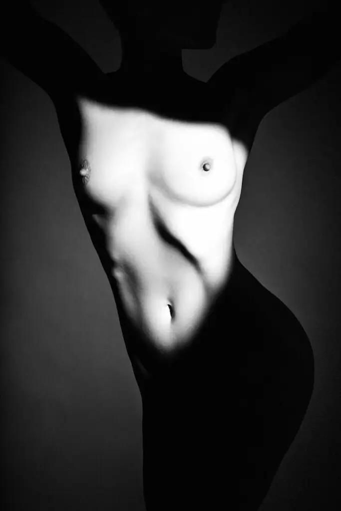 figure study black and white image of slender nude model using creative shadows and spotlight