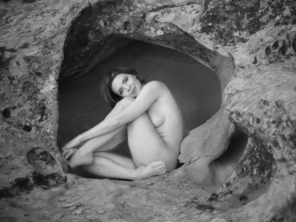 Kristy Jessica Art Nude in Utah Landscape black and white implied curled up pose eye contact