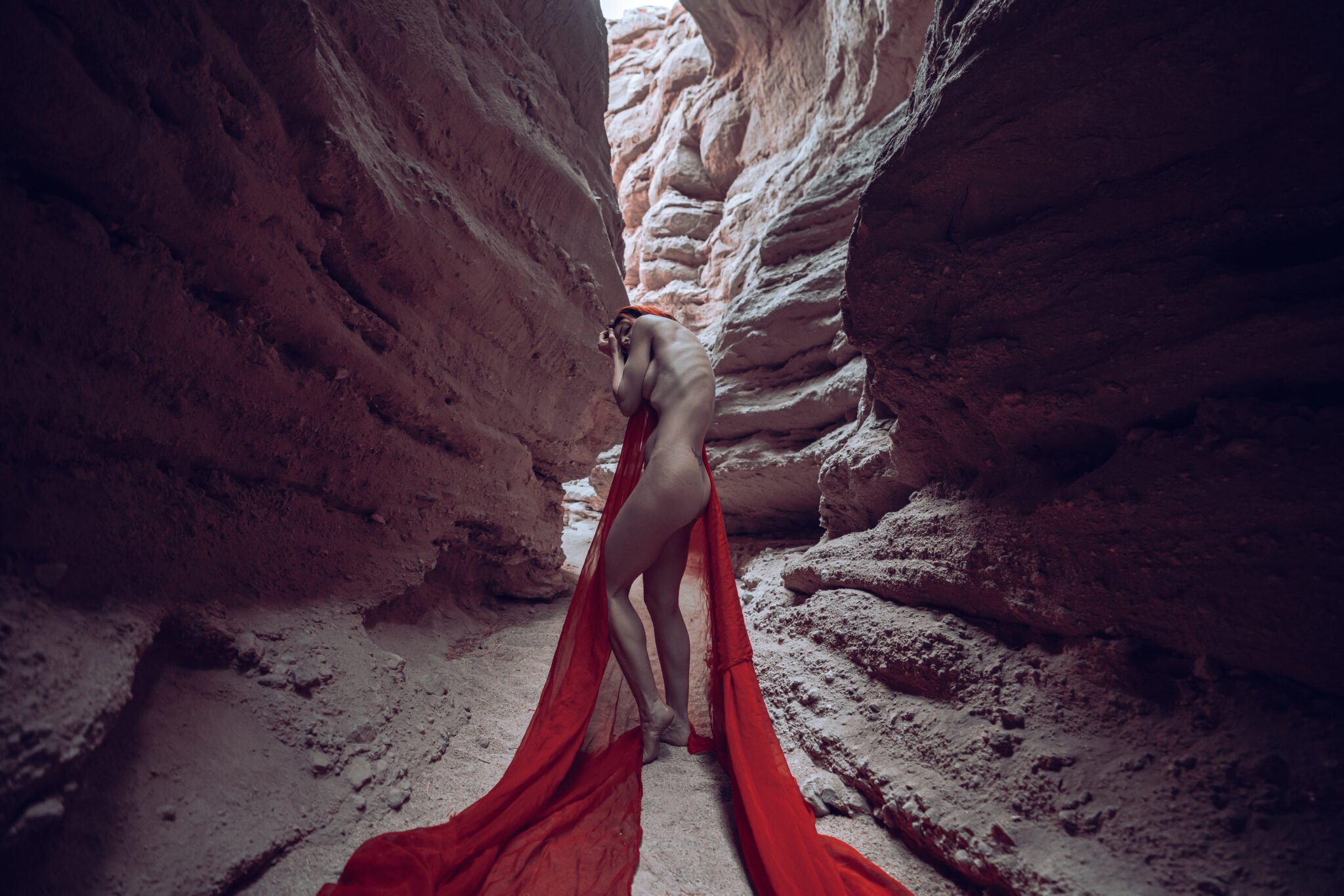 Kristy Jessica art nude model in slot canyon with red fabric showing ribs