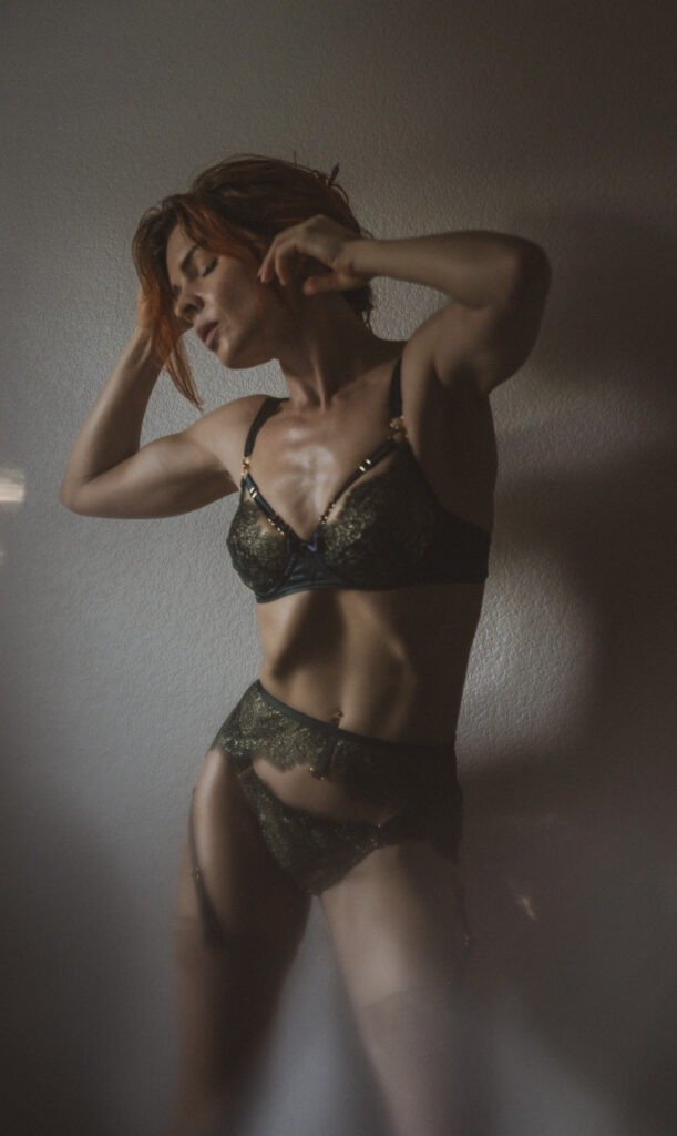 Shadowy artistic boudoir in dark room with slender model posing in dark lingerie. Kristy Jessica